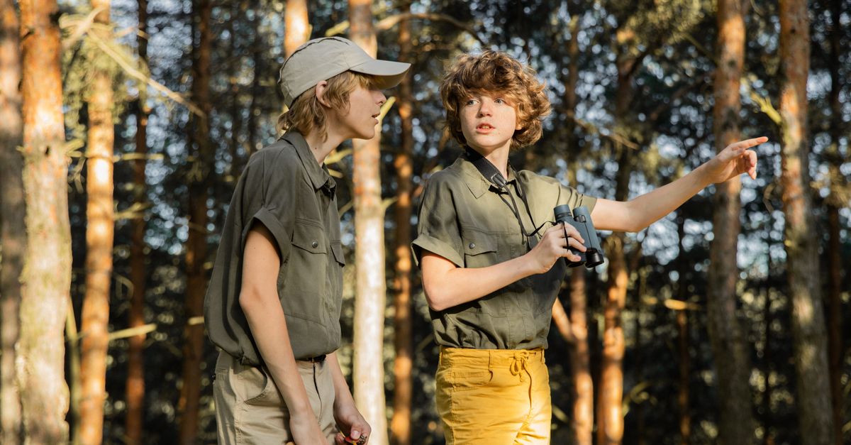 Two kids enjoying a summer adventure in the forest, discovering nature.